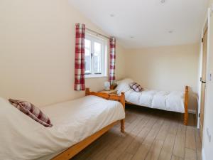 a bedroom with two beds and a window at The Granary in Halstead