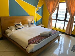sypialnia z dużym łóżkiem z żółtymi i niebieskimi ścianami w obiekcie JJ Homes Marina Court w mieście Kota Kinabalu