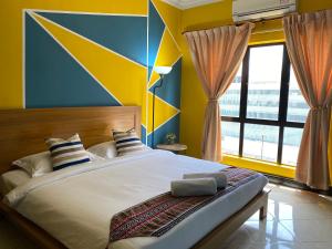 sypialnia z dużym łóżkiem z niebieskimi i żółtymi ścianami w obiekcie JJ Homes Marina Court w mieście Kota Kinabalu
