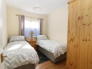 een slaapkamer met 2 bedden en een houten kast bij Smallcroft in Whitstable