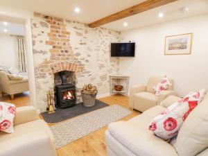 ein Wohnzimmer mit einem Kamin und einem Sofa in der Unterkunft Quarry House in Oswestry