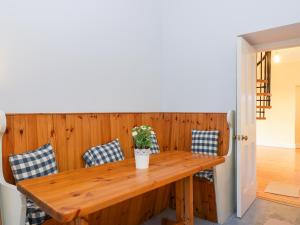 einen Holztisch mit blau und weiß gepolsterten Stühlen um ihn herum in der Unterkunft Rosemount Cottage in Helensburgh