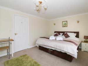 ein Schlafzimmer mit einem großen Bett und einem Kronleuchter in der Unterkunft The Duck House in Norwich