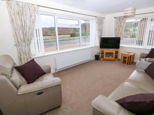 a living room with a couch and a television at Elliott's Retreat in Sheringham