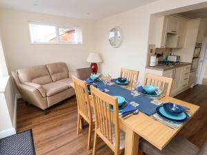 a dining room and living room with a table and chairs at Elliott's Retreat in Sheringham