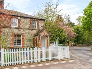 uma cerca branca em frente a uma casa de tijolos em 3 Station Cottages em Wymondham