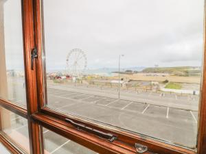 een raam met uitzicht op het strand en het reuzenrad bij Apartment 42 in Bundoran