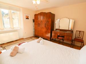 a bedroom with a bed and a dresser and a mirror at Surf Song in Penzance