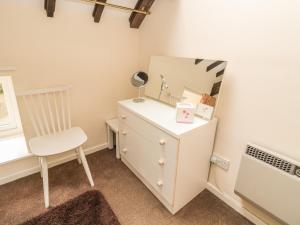 a dresser with a mirror and a chair in a room at Wren Cottage in Morpeth +15 photos