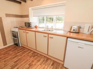 a kitchen with a sink and a microwave at Heron Cottage in Morpeth