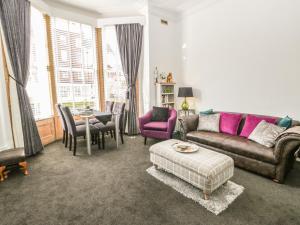 a living room with a couch and a table at Esplanade Gardens, Apartment 1 in Scarborough