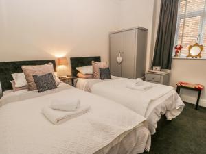 a bedroom with two beds with towels on them at Esplanade Gardens, Apartment 1 in Scarborough