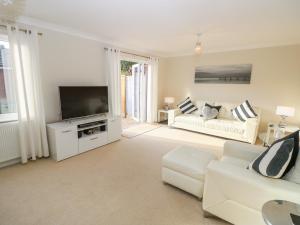 a living room with a white couch and a tv at Chinefields in Freshwater