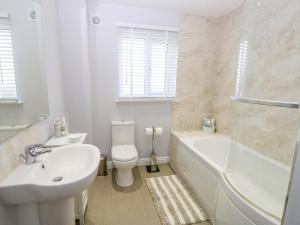 a white bathroom with a tub and a toilet and a sink at Chinefields in Freshwater +17 photos