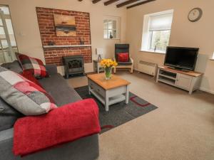 a living room with a couch and a fireplace at Magpie Cottage in Morpeth