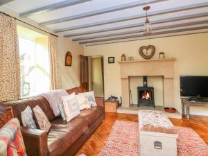 a living room with a couch and a fireplace at Beech House in Leek