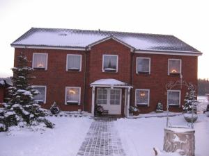 una casa de ladrillo rojo con nieve en el suelo en Ferienhaus Tobie, en Ahlefeld