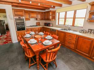 a kitchen with a wooden table and chairs at Park Hall Cottage in Haverfordwest