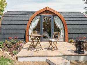 een cirkelvormige woning met een tafel en stoelen ervoor bij Chapel Pod in Saltash