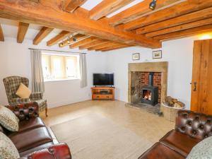 a living room with a couch and a fireplace at Woodthorpe Cruck Cottage in Chesterfield