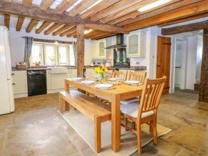 a dining room with a wooden table and chairs at Woodthorpe Cruck Cottage in Chesterfield