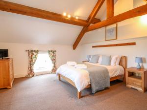 A bed or beds in a room at Woodthorpe Cruck Cottage