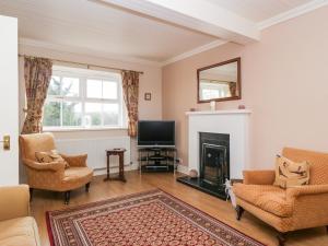 a living room with a fireplace and a tv at Cairnhill in Girvan