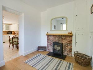 a living room with a brick fireplace and a mirror at The Old School House in Dorchester