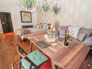 a living room with a table and a couch at The Cottage The Coach House in Wrexham