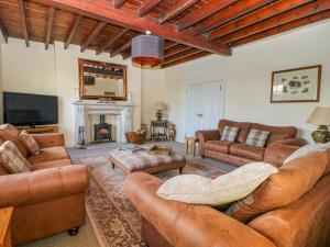 a living room with leather furniture and a fireplace at Tuft House in York