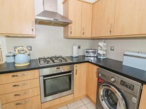 a kitchen with a stove and a washing machine at Bright and Beautiful in Ayr