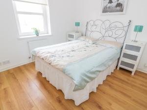 a bedroom with a large bed with a metal headboard at Bright and Beautiful in Ayr