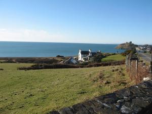ein Haus auf einem Hügel neben dem Meer in der Unterkunft Cae'r Dyni Caer Dyni in Criccieth