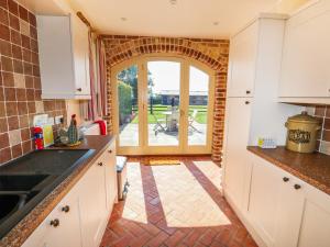 a kitchen with an open door to a patio at Owl's Roost in Alford
