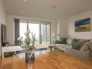 a living room with a vase of flowers on a table at Chapel Rock View, The Dunes in Perranporth