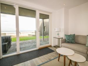 a living room with a couch and a view of the ocean at Chapel Rock View, The Dunes in Perranporth