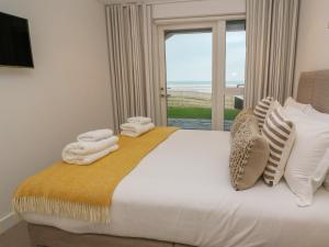 a bedroom with a bed with a view of the ocean at Chapel Rock View, The Dunes in Perranporth