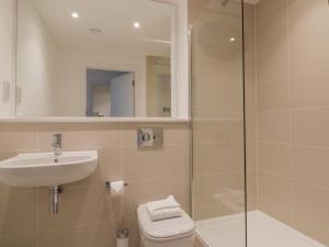 a bathroom with a toilet and a sink and a shower at Chapel Rock View, The Dunes in Perranporth