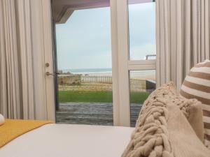 a bedroom with a bed and a view of the ocean at Chapel Rock View, The Dunes in Perranporth