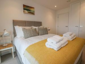 a bedroom with a bed with white towels on it at Chapel Rock View, The Dunes in Perranporth