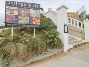 a sign for a sunstroke day restaurant next to a building at Chapel Rock View, The Dunes in Perranporth
