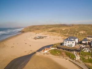 an aerial view of a beach with houses and the ocean at Chapel Rock View, The Dunes in Perranporth
