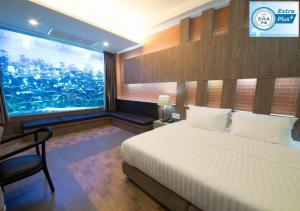 a bedroom with a bed and a large window at V20 Boutique Jacuzzi Hotel - SHA Extra Plus in Bangkok