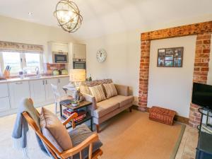 a living room with a couch and a kitchen at The Dairy in Lincoln