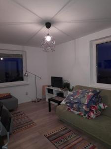Apartament Widokowo في سوبوت: غرفة معيشة مع أريكة ومروحة سقف
