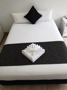 - un lit blanc avec une couverture noire et un anneau dans l'établissement Original North Australian, à Bowen