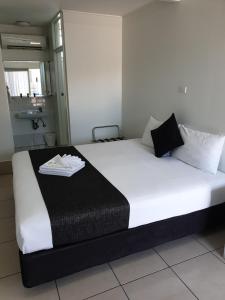 - un grand lit blanc avec une couverture noire dans l'établissement Original North Australian, à Bowen
