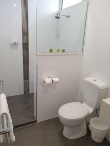 La salle de bains blanche est pourvue d'une douche et de toilettes. dans l'établissement Original North Australian, à Bowen