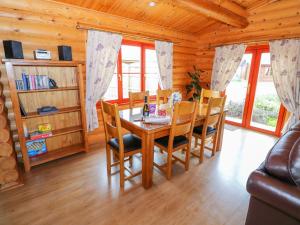 una sala da pranzo con tavolo e sedie in una cabina di Willow Lodge a Oakham