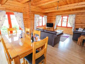 a dining room and living room in a log cabin at Willow Lodge in Oakham